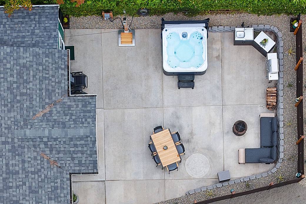 The finished courtyard from above, poured concrete with hot tub, dining, fire pit and cedar fence